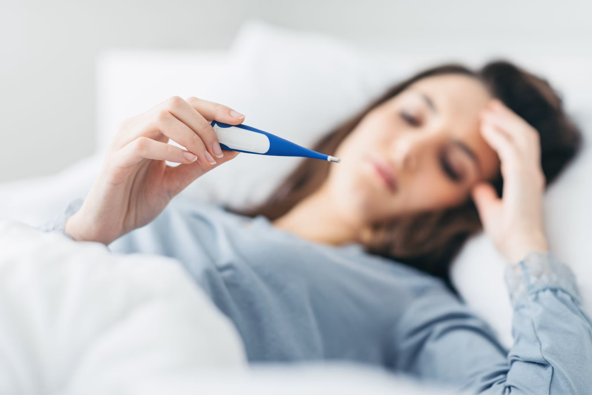 Woman reading thermometer-Acanthamoeba Woman lying in bed reading thermometer