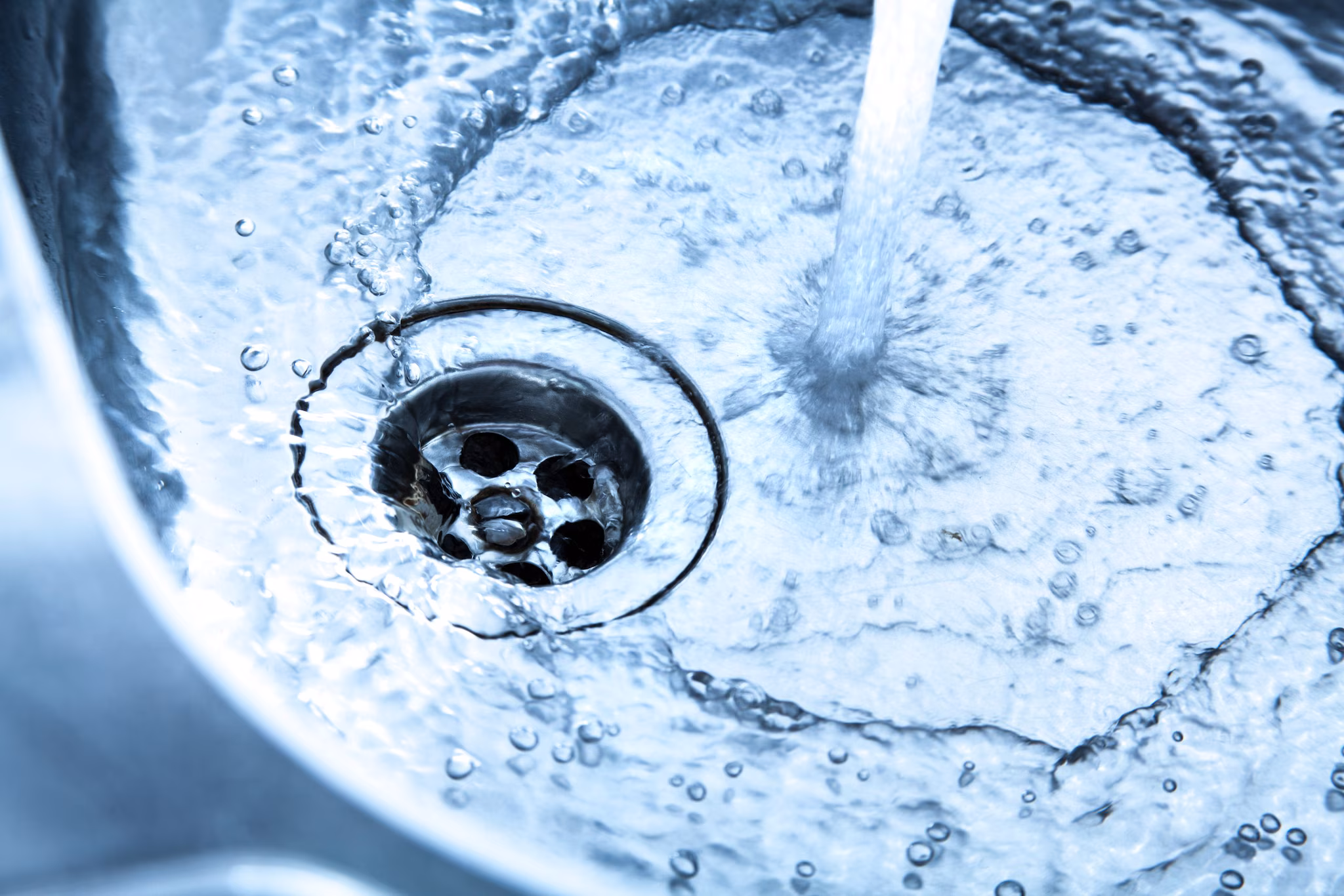 Water and Drain Image Water from faucet swirling down a drain