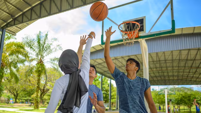 — title missing — Three people playing basketball.