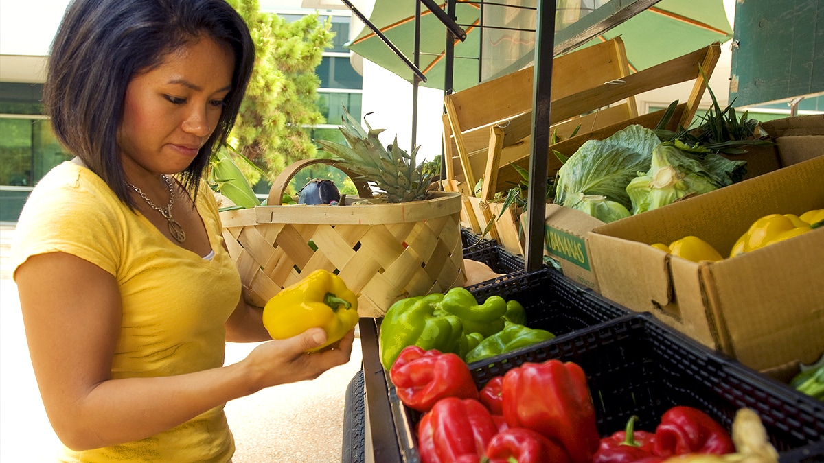 cyclosporiasis-1200 Woman standing in a farmer's market considering her purchase.
