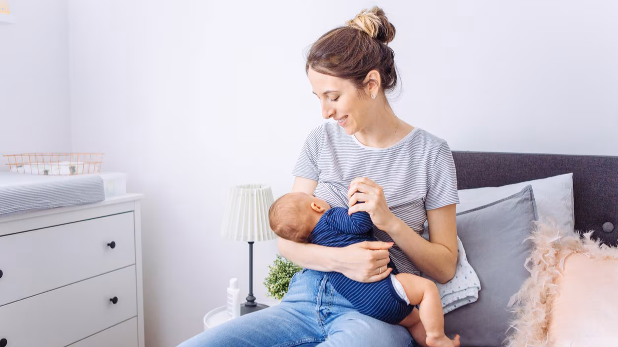 Mother breastfeeding baby in bedroom