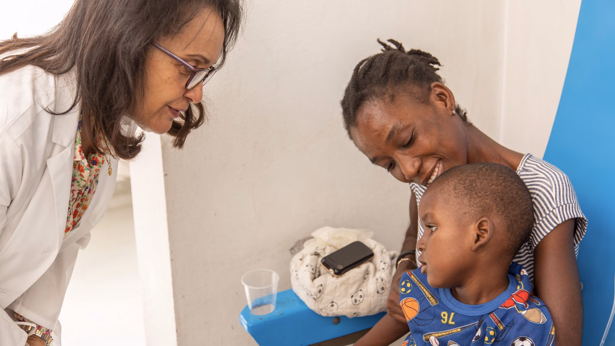 Family_Haiti_UnicefCDC A healthcare provider talks to a mother and her young son.