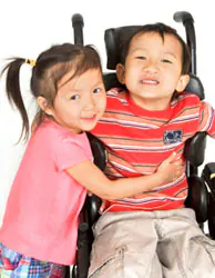 Child with Spina bifida A child with spina bifida is hugged by his sister.