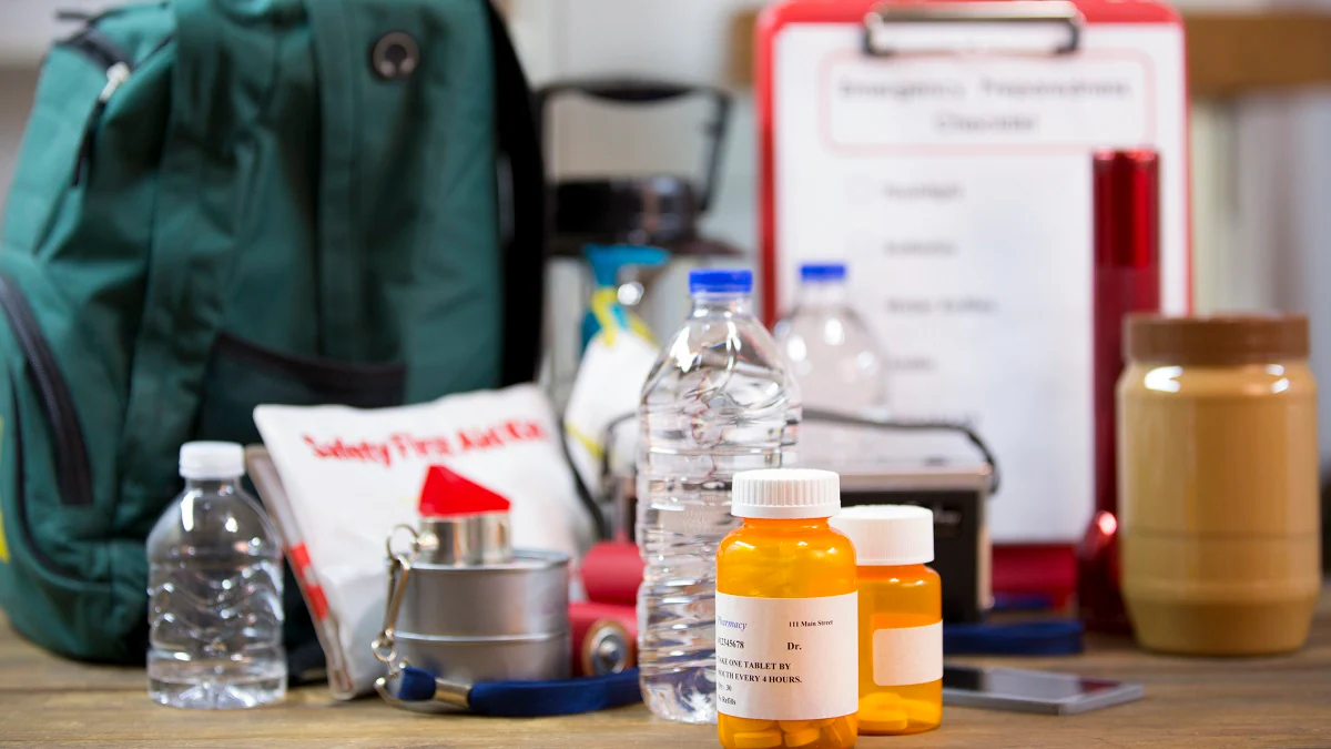 Emergency kit Emergency preparedness items, including a backpack, first aid kit, medications, and bottled water.