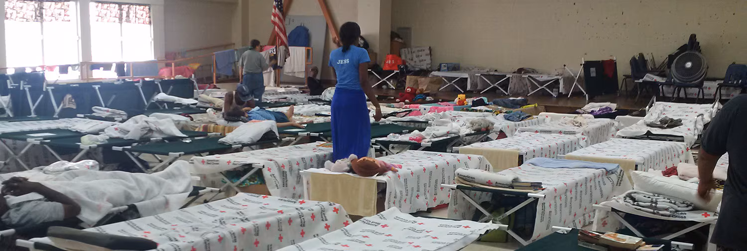 Bunk room for emergency shelter with cots set up in rows