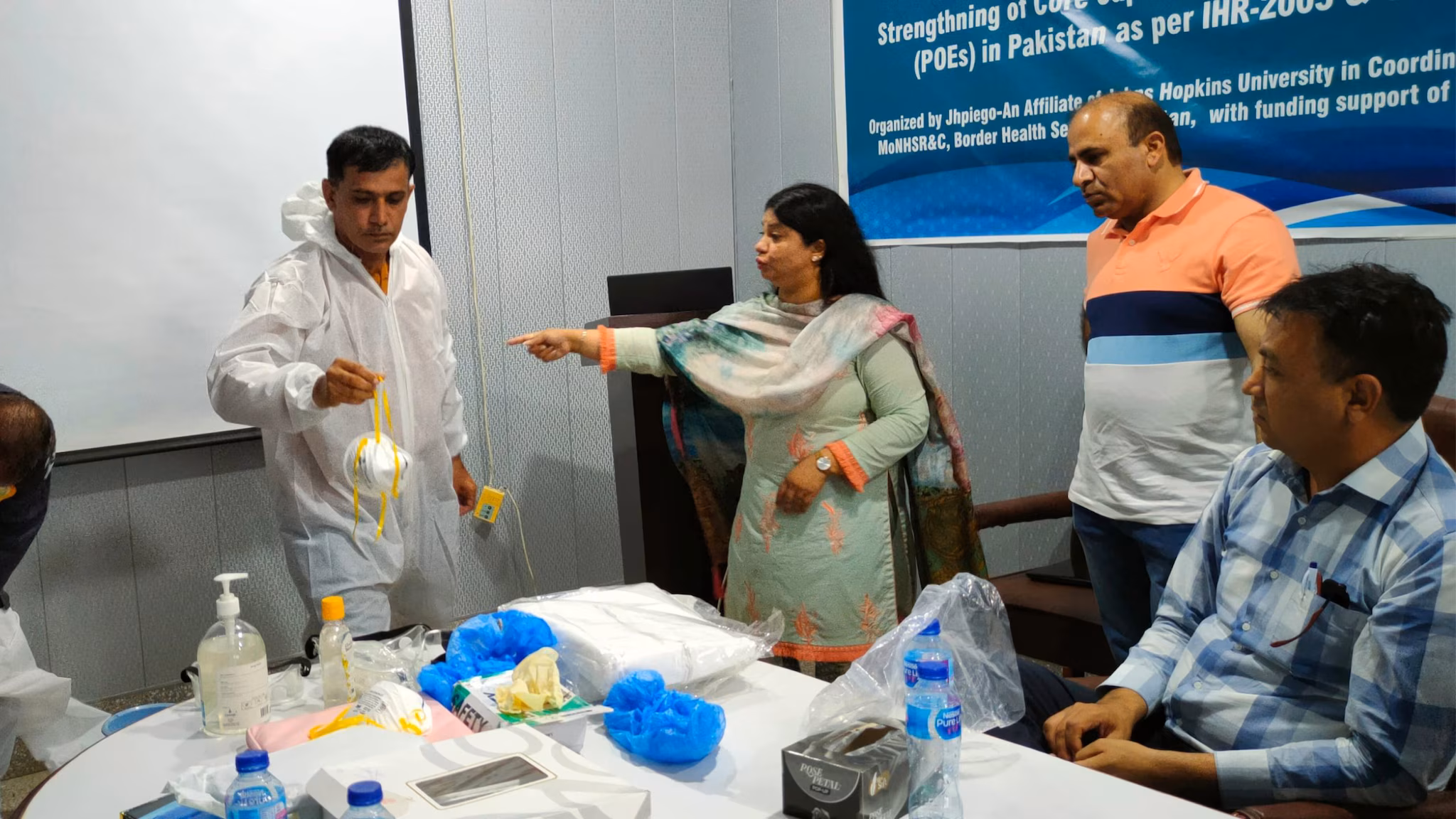 Pakistan-FELTP-1 Dr. Nadia Noreen working with team to demonstrate correct procedures for personal protective equipment