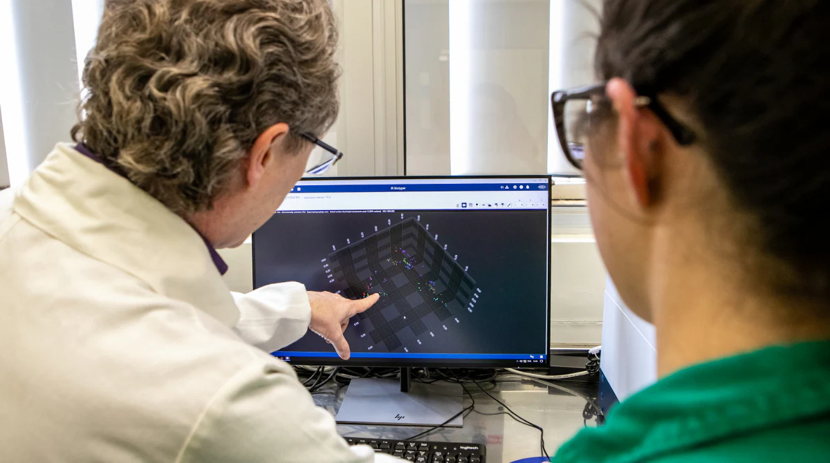 Laboratory data and surveillance Person points at desktop computer with data visualization used to identify bacteria that might be resistant.