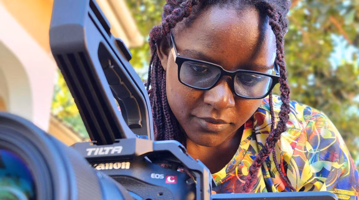 -- title missing -- Woman wearing glasses managing a video camera.