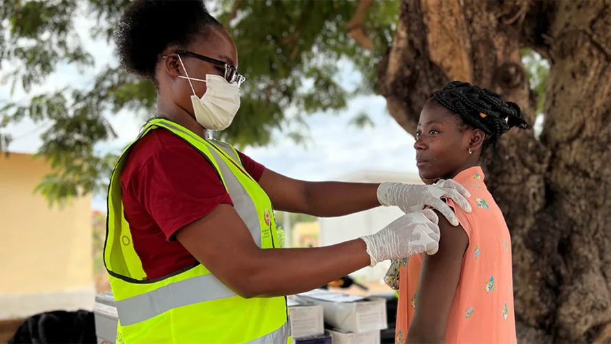 A health worker at a U.S.CDC-supported vaccine site. Healthcare worker vaccinates teen.