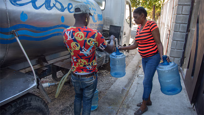 Cholera Response Work in Haiti_005 A worker fills water containers from a mobile tanker that provides clean drinking water to families in Haiti’s capital.