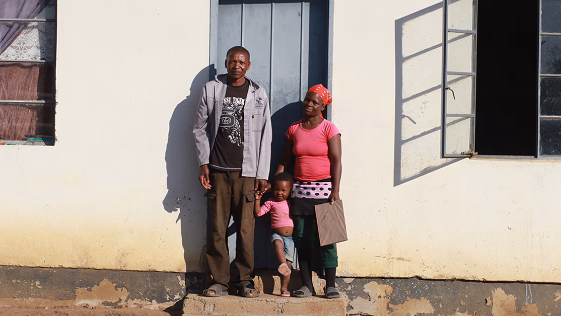 Family in front of home with blue door.