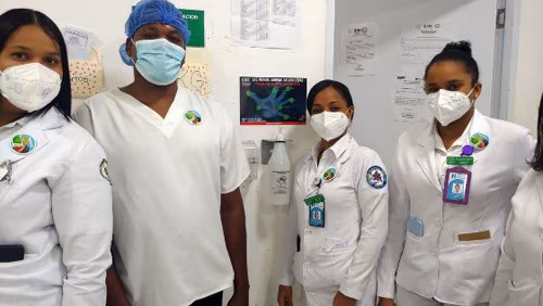 Hand Hygiene Champions Hand Hygiene Champions pose in front of ABHR dispenser in San Pedro de Macoris, Dominican Republic.