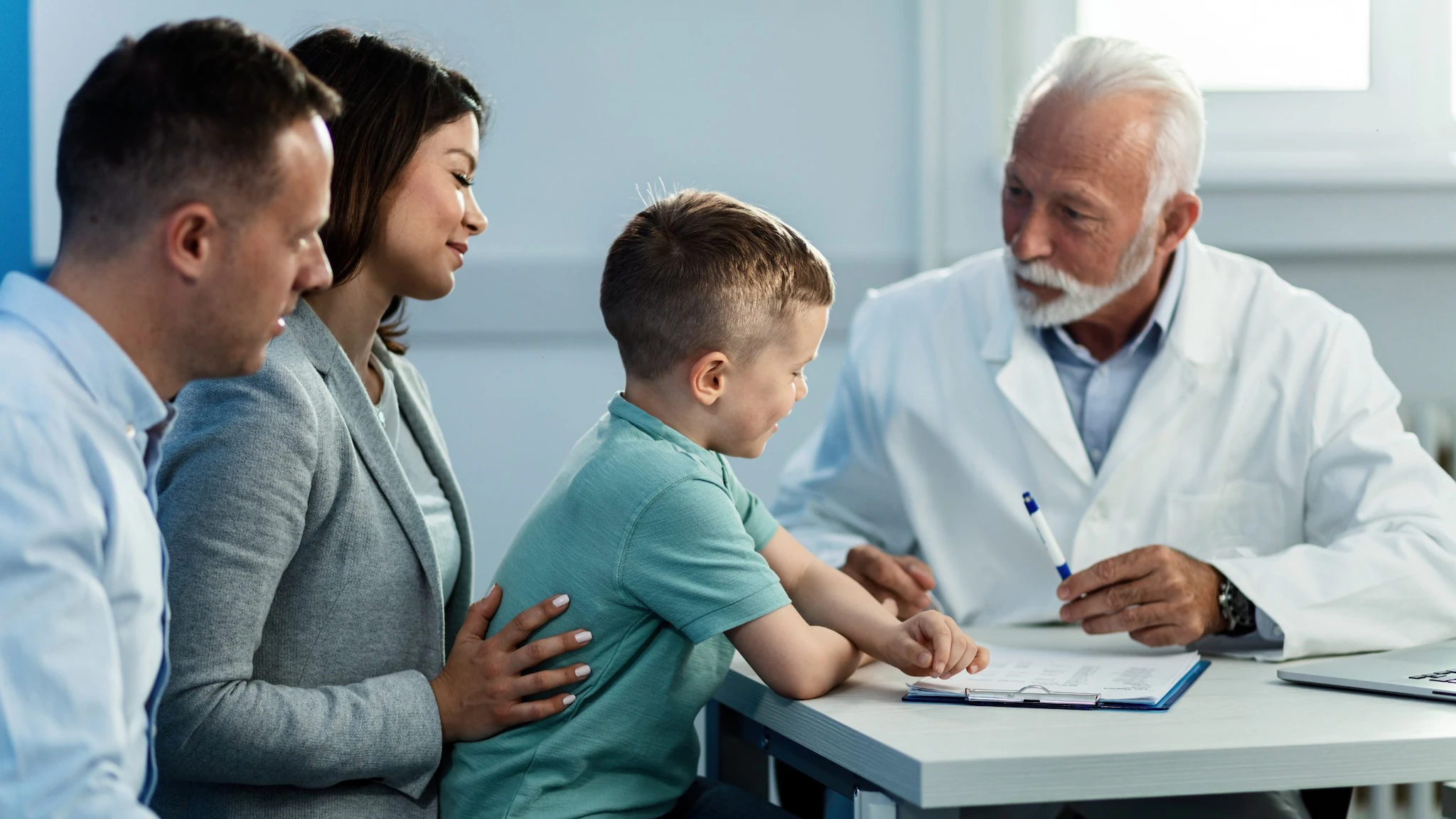 Health care provider talking to father and son A healthcare provider talking to a couple and their chlid.