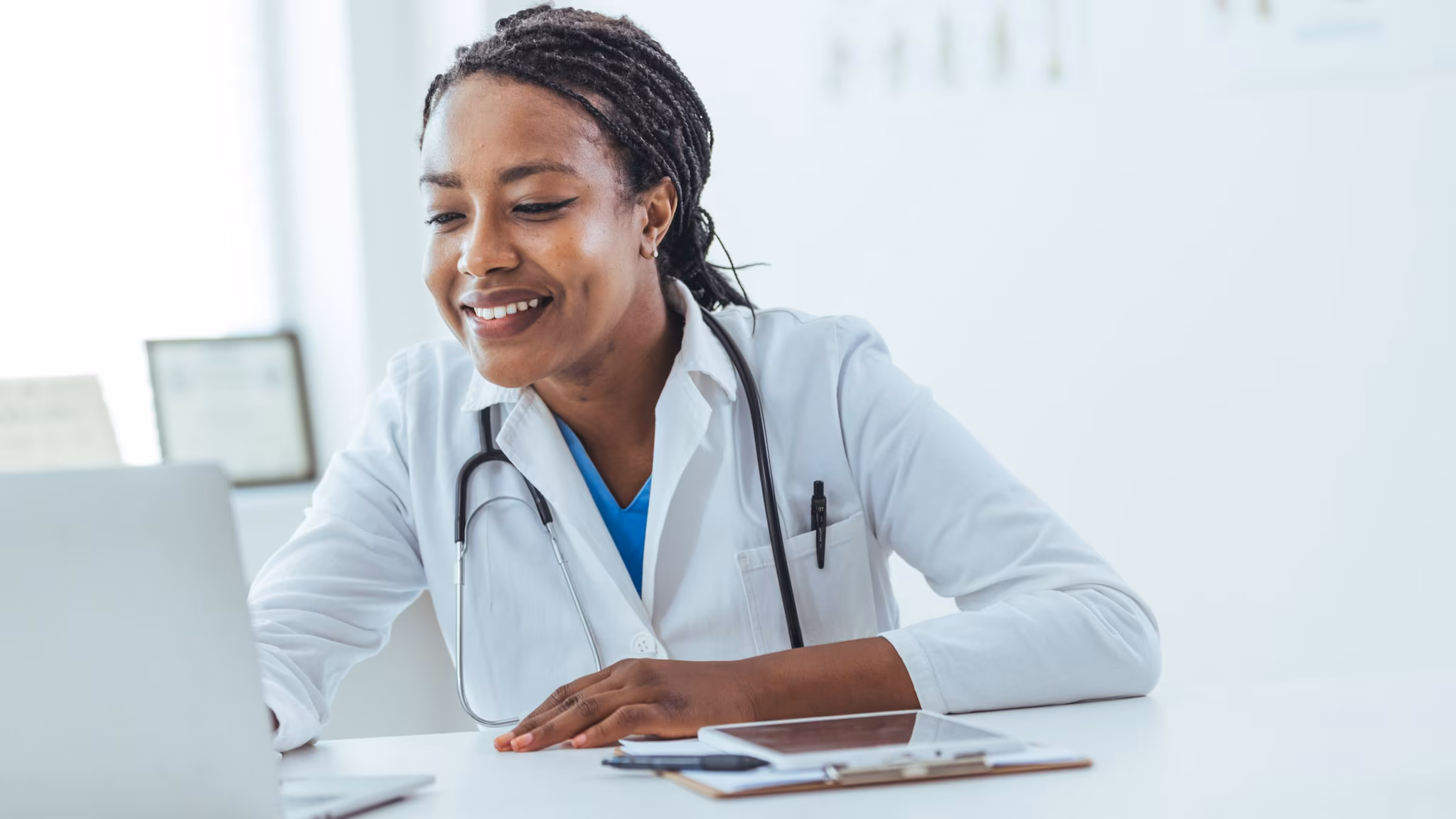 Doctor at laptop A smiling healthcare provider studies at a laptop.