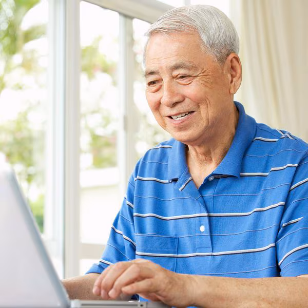 A senior man using a laptop at home Senior man using laptop computer