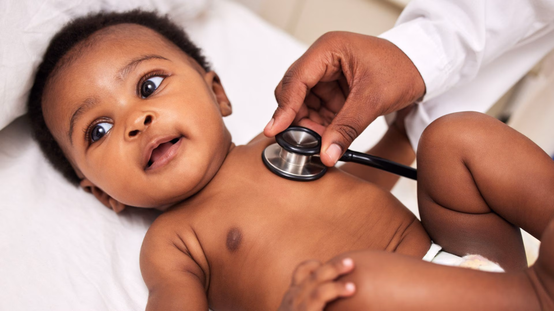 Caregiver listening to a baby's heart A Heathcare worker is listening to a baby's heart