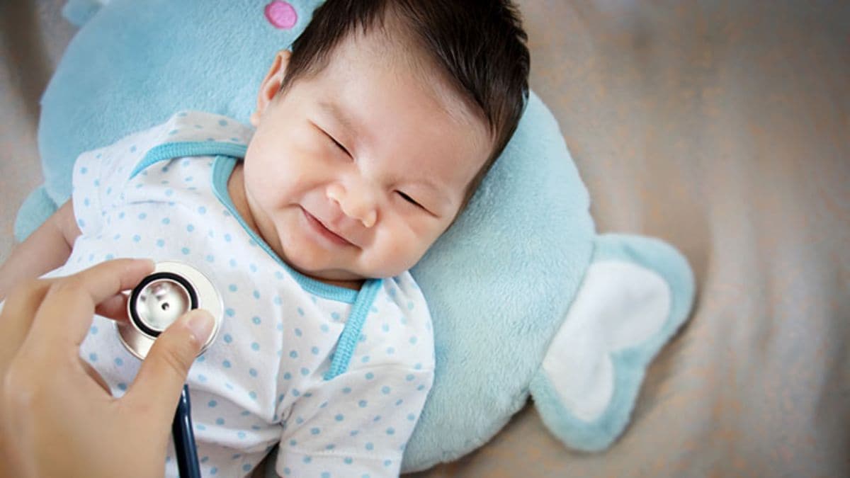Doctor listening to toddler's heart while toddler is laying on stuffed animal Doctor listening to toddler's heart while toddler is laying on stuffed animal