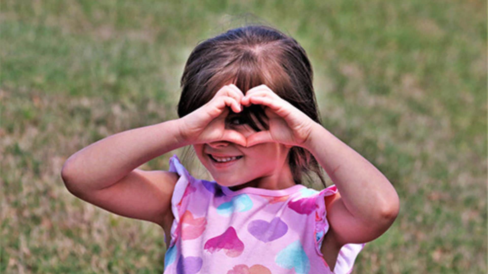 — title missing — Little girl making heart gestures