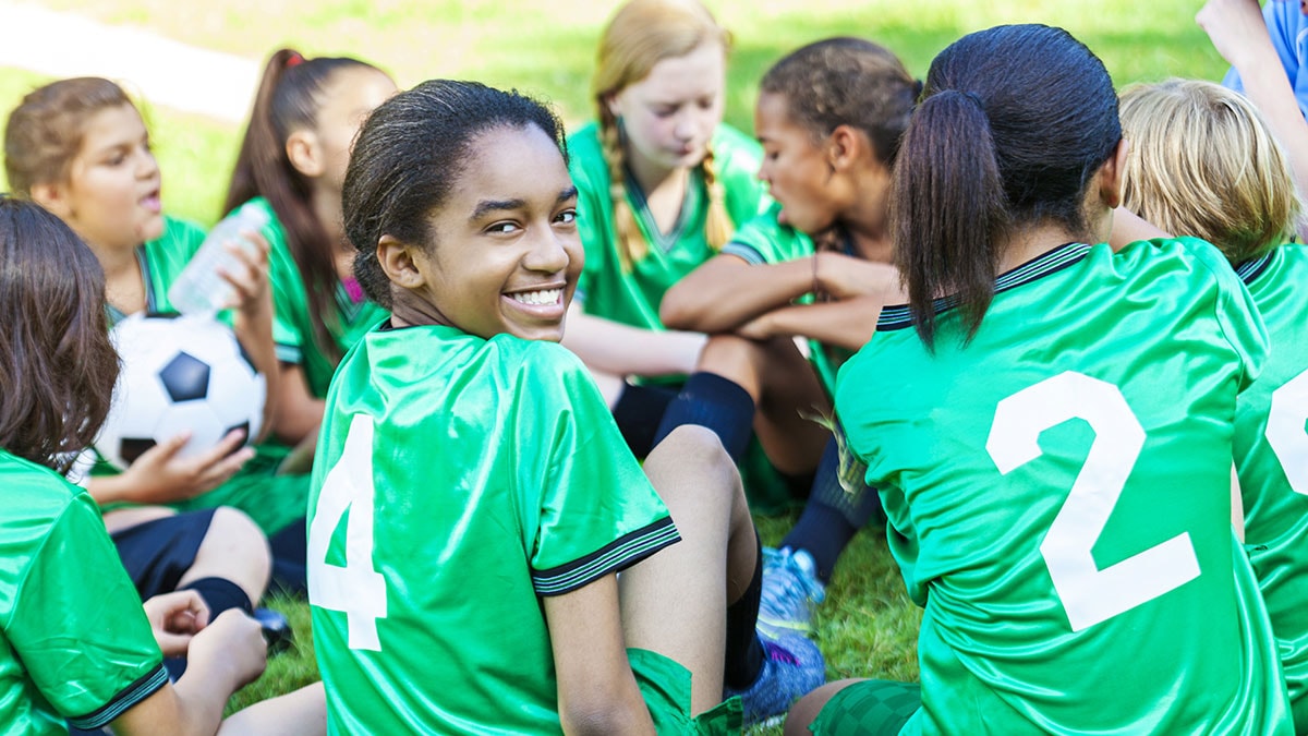 African American girl smiling with her soccer team