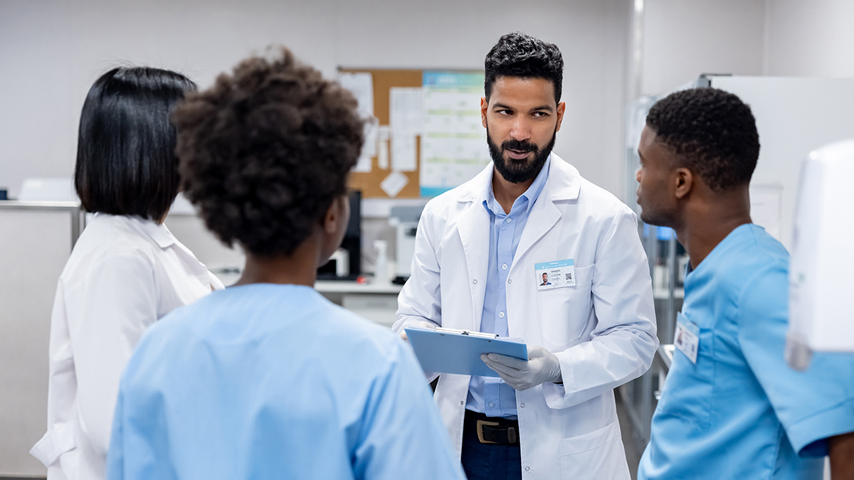 Responding to HBV Exposures in Healthcare Settings Thumbnail A group of four medical professionals speaking in a doctor's office