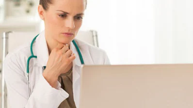 Provider at computer Doctor reading from a laptop