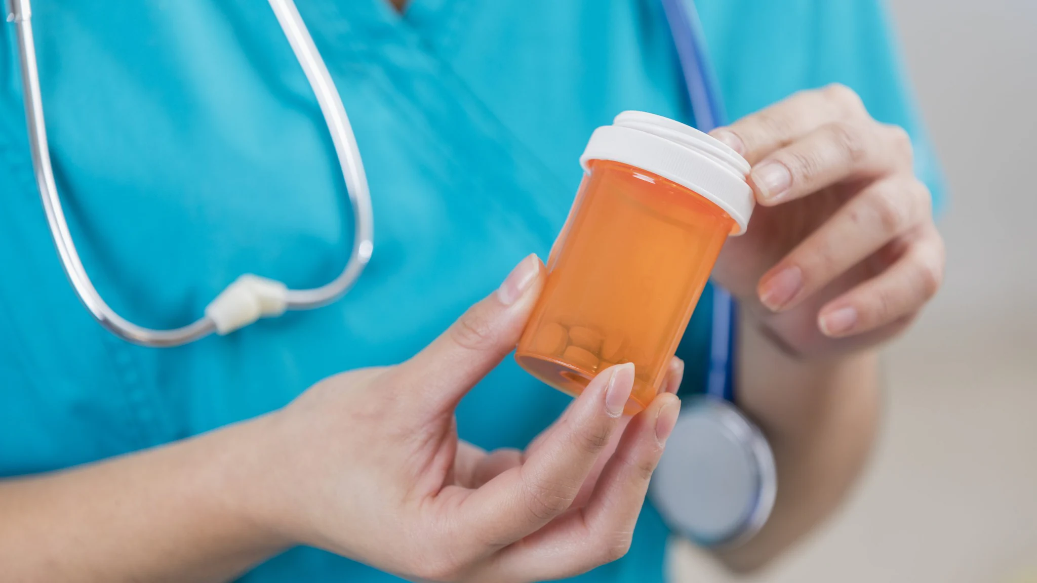Doctor holding an orange pill bottle