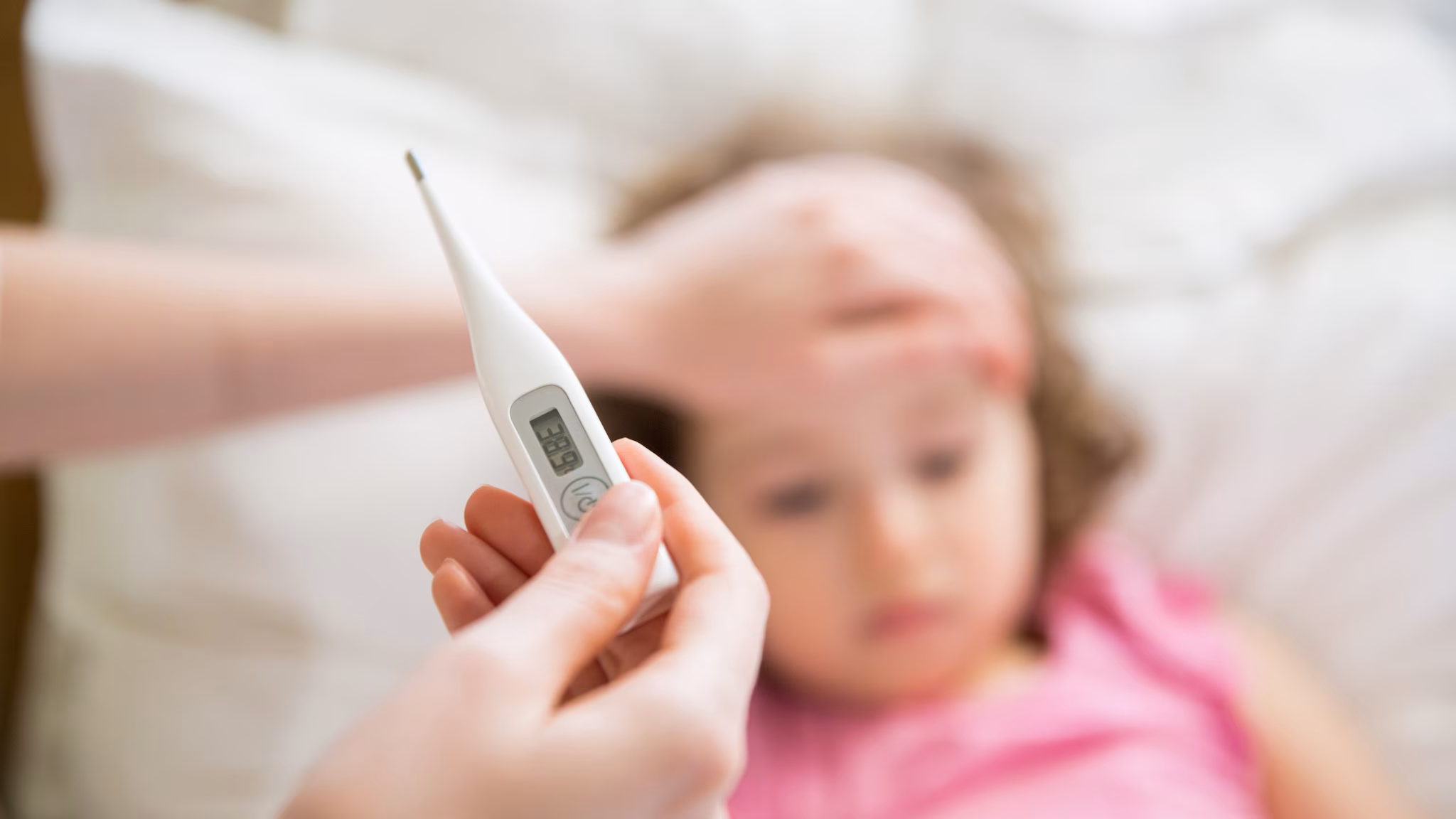 Parent checking child's tempature with a thermometer