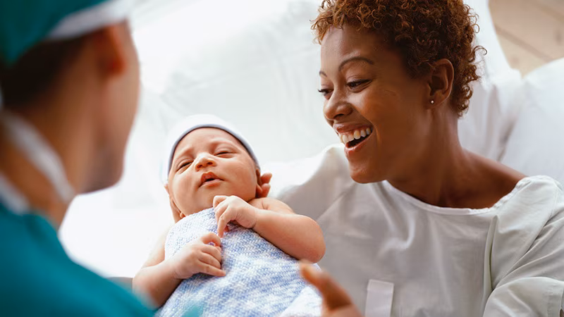 doctor putting infant in mother's arms