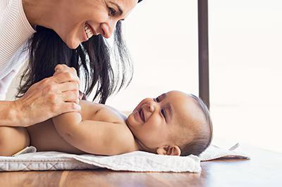 Mother changing diaper to toddler