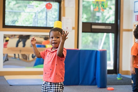 LTSAE Milestones 30 month year old baby standing with toy on head