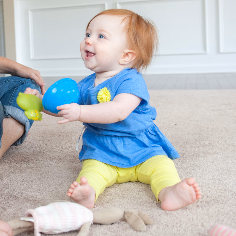 A young girl bang her toys together