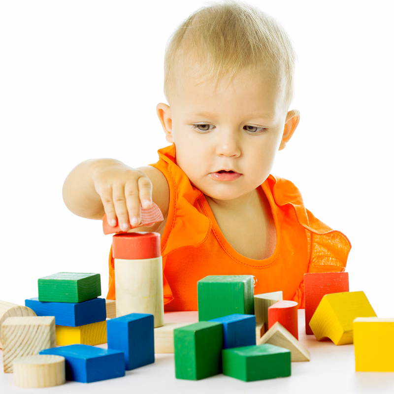 A boy builds a tower out of blocks.