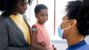 Boy_Mom_Nurse_Bandaid1 Mother with young son with Band-Aid on his arm sitting in exam room talking with doctor
