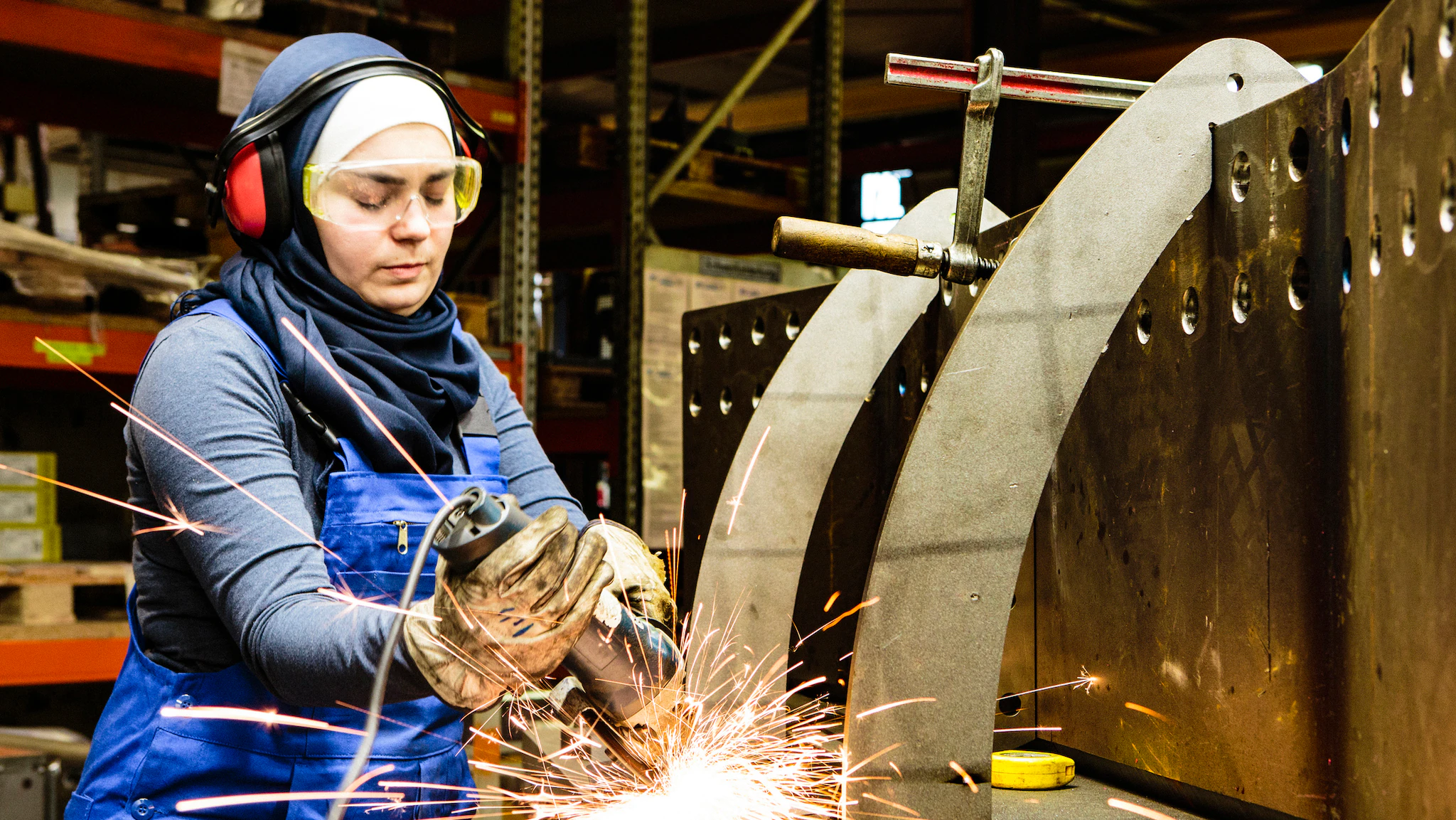1051092562 A female worker in PPE is shown working in an industrial setting.