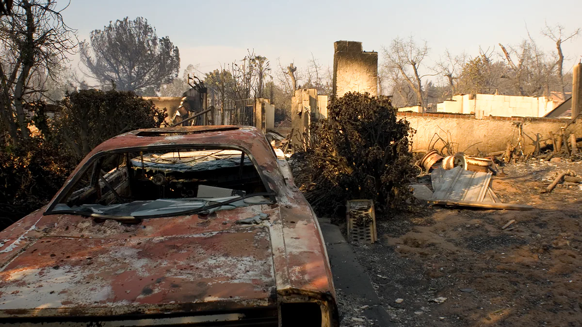 WFF Cleanup Main Image Burned remains of vehicle and house after wildland fire in California. iStock/Getty Images/Plus