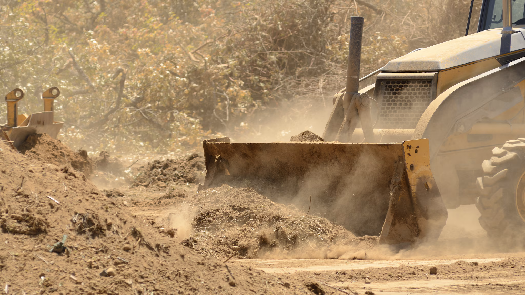 — title missing — Bulldozer pushing dirt with dust.