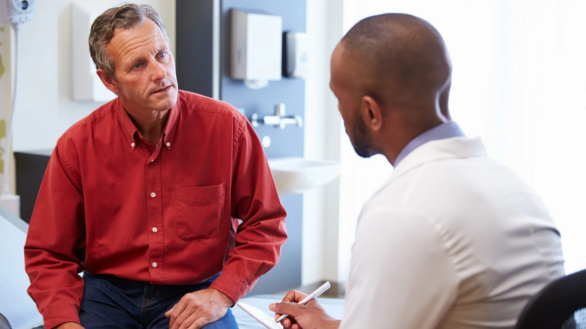 — title missing — Doctor talking with patient and taking notes.