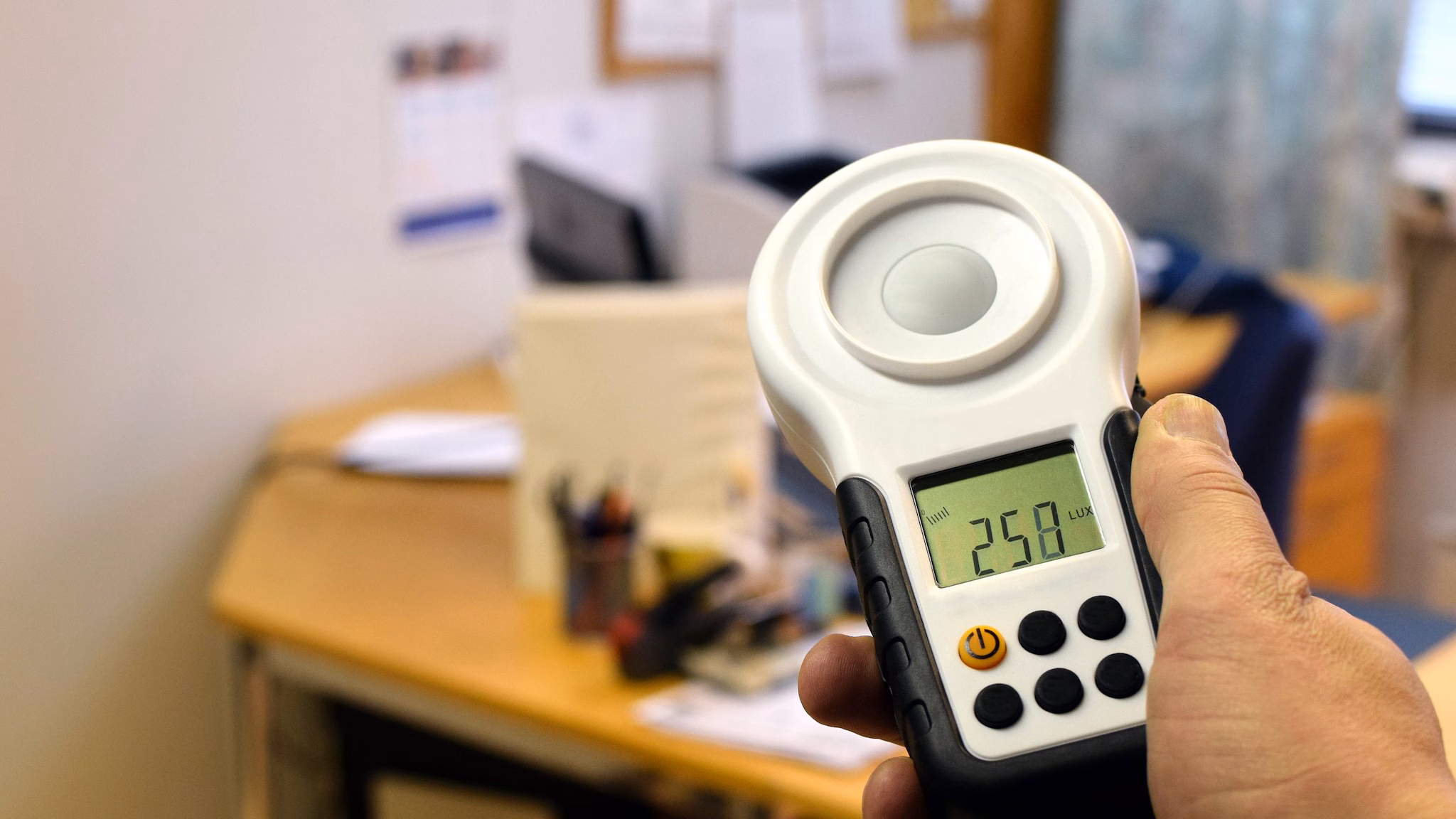 Measuring office lighting with lux meter.