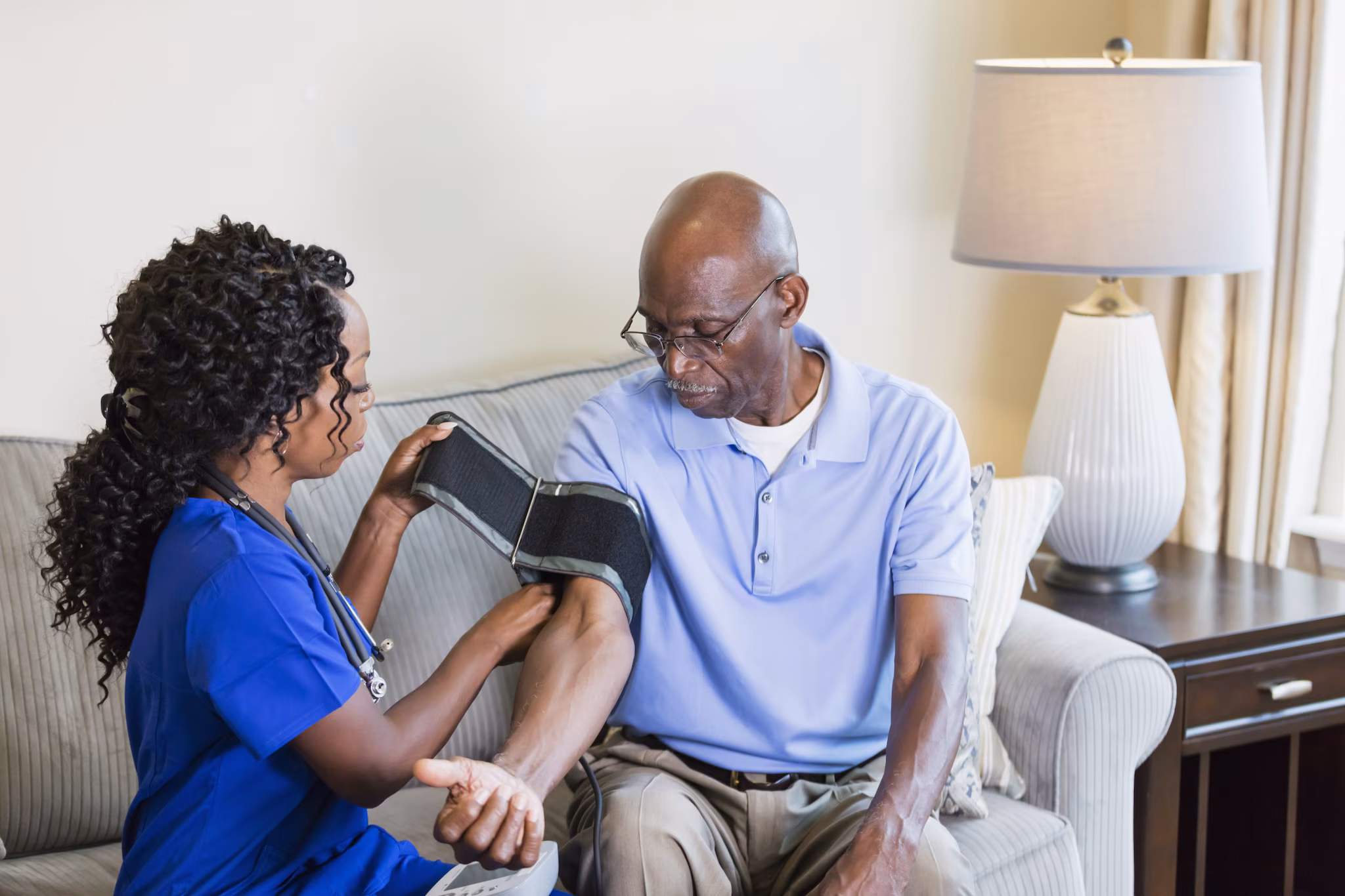 -- title missing -- home nurse checking a senior man's blood pressure.