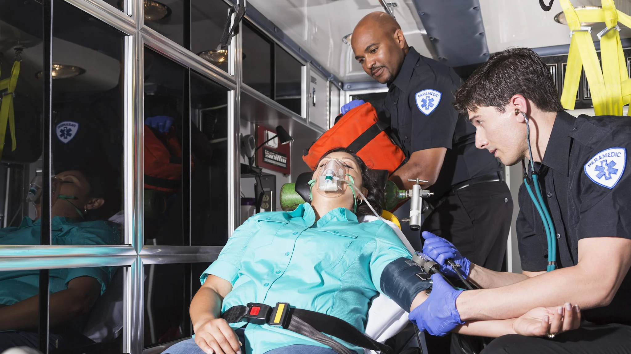 — title missing — Two EMS clinicians help a patient in an ambulance. Photo by Getty/482584125