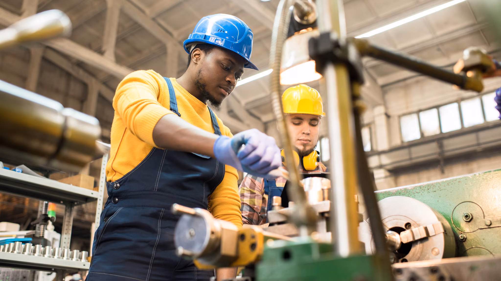 — title missing — lathe operators wearing protective helmets