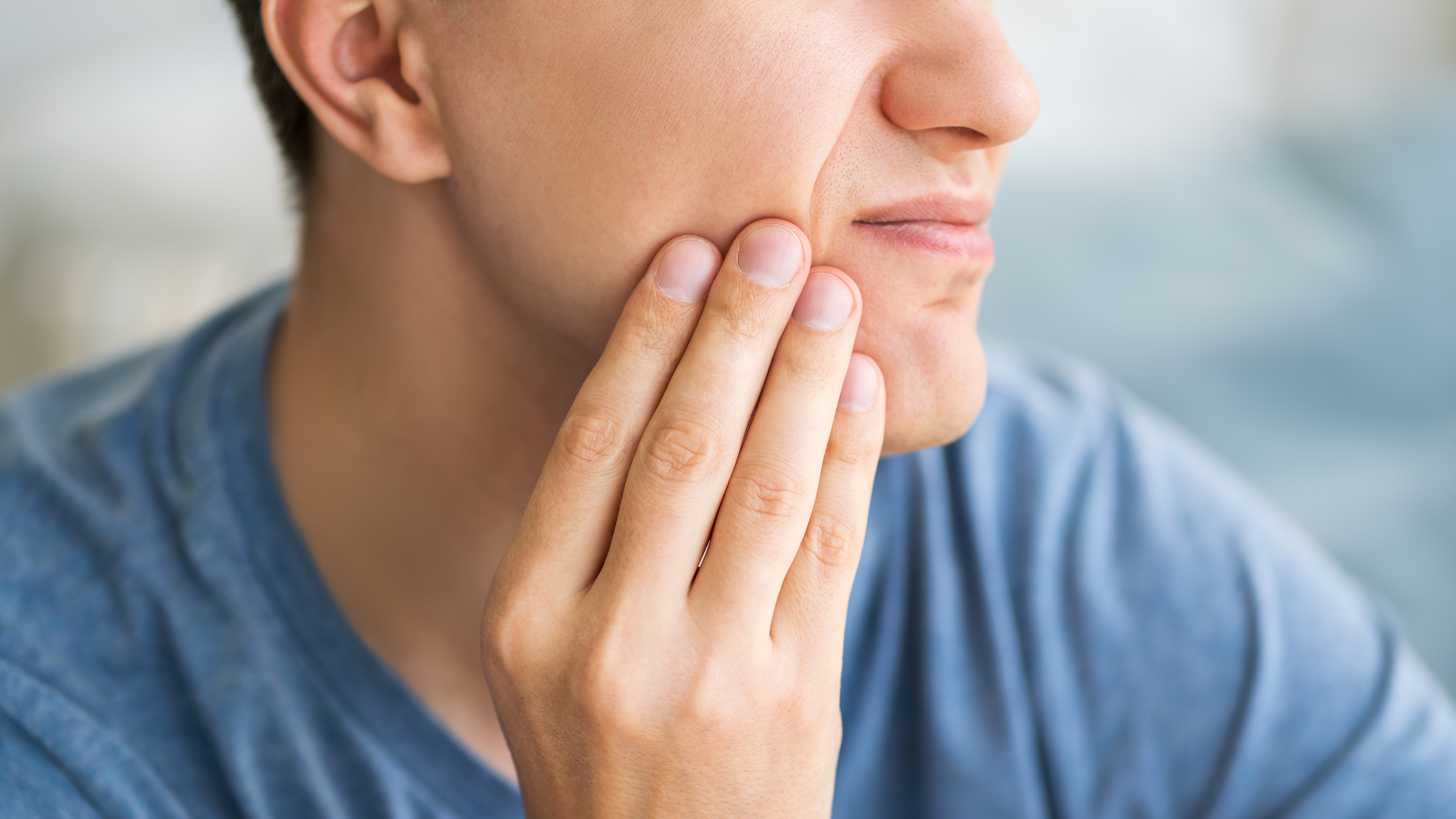 FF Cavities Thumbnail A male with his hand on his cheek having tooth pain