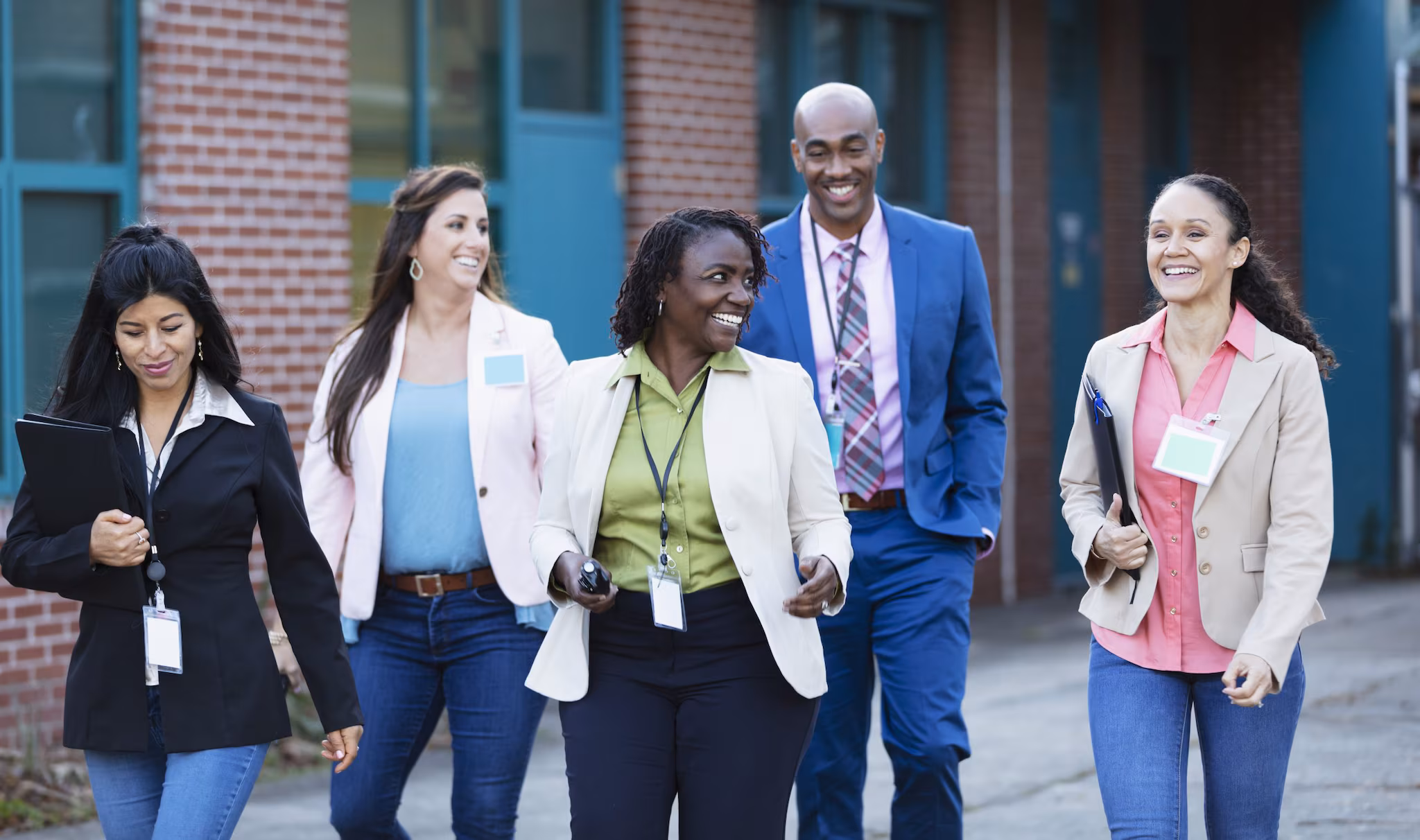 Staff members standing outside of a school. Staff members standing outside of a school.