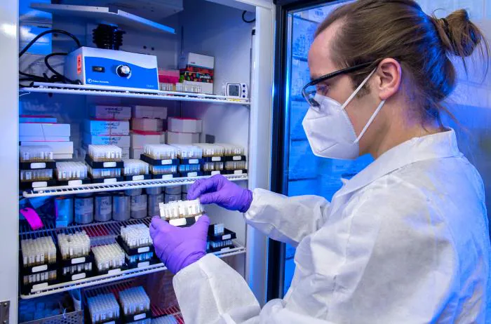 Inventory lab Laboratory inventory female lab tech wearing PPE holding sample.
