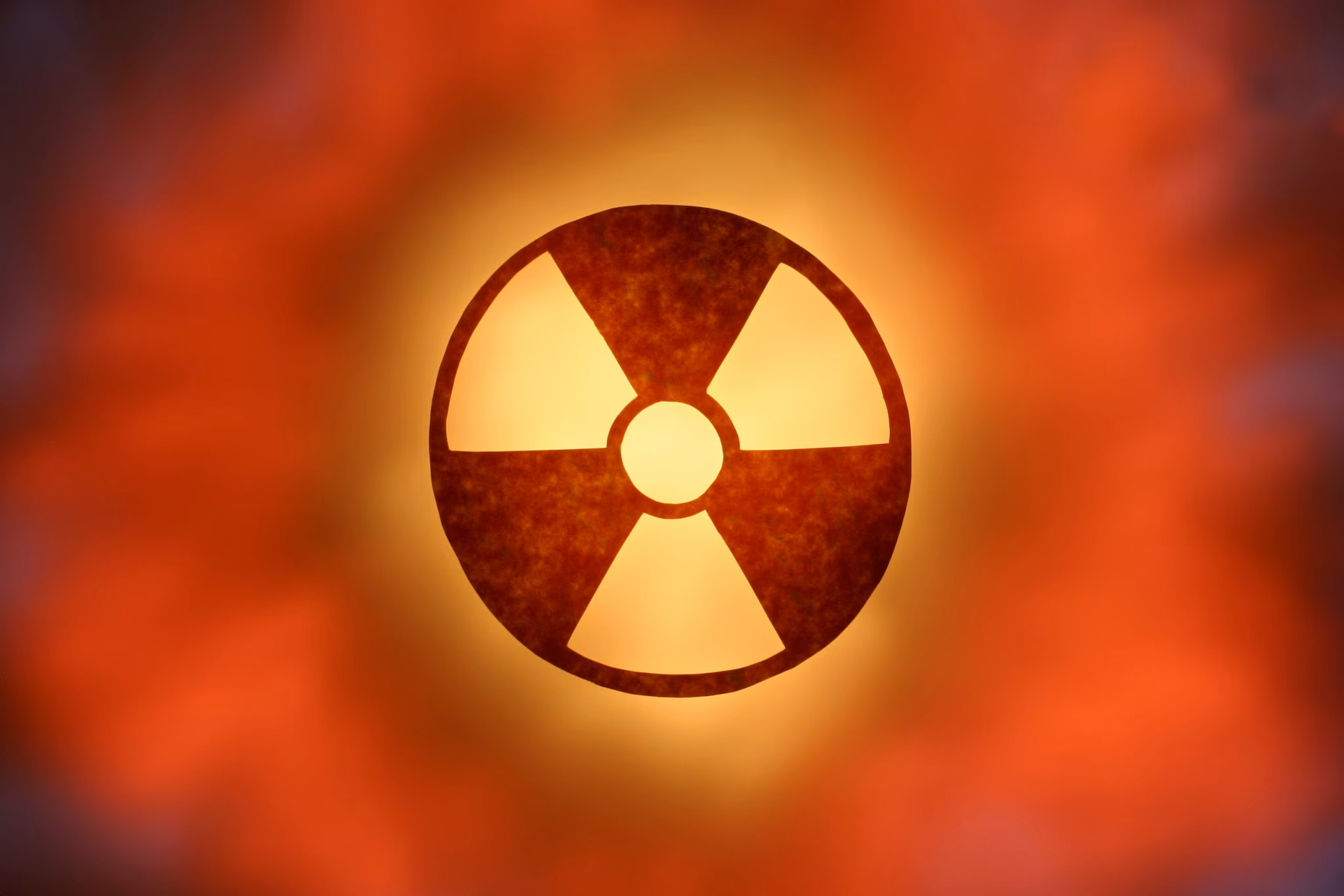 Red-orange colored glowing radioactive symbol