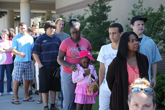 — title missing — A diverse group of people waiting in line.