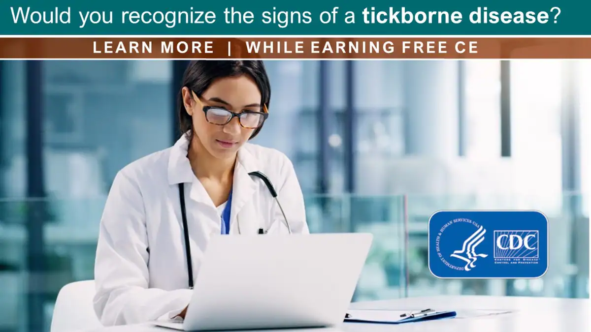 Dr CE A healthcare professional at a desk works on a notebook computer.