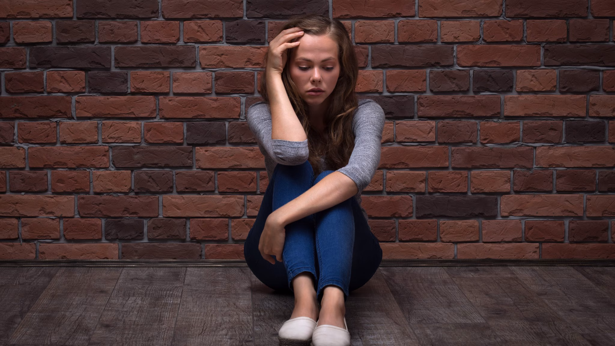 Depressed Teenager Girl Sitting Depressed Teenager Girl Sitting against a brick wall