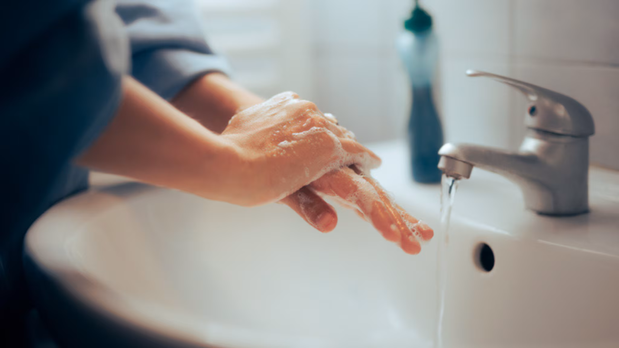 Woman washing hands in bathroom sink