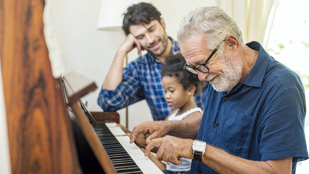 Family spend time happy together. Grandfather playing piano… Family spend time happy together with the grandfather playing piano